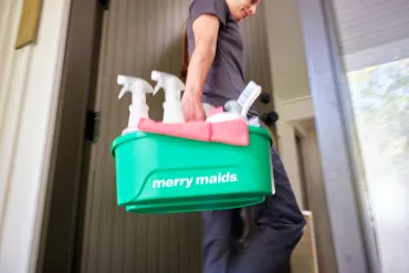merry maid carrying cleaning supplies